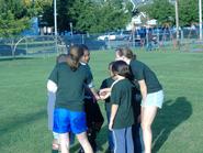 Katy McElroy '08 and Haley Peterson '11 huddle with their CYS soccer team.